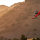 The kittyhawk Heaviside red and silver air taxi flying off toward a sunset